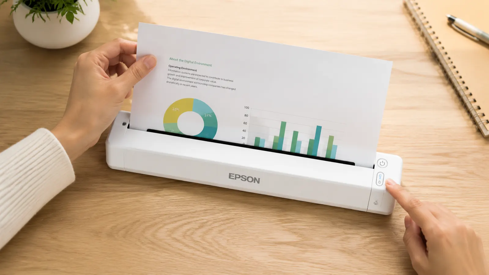 Hand sliding a single document sheet into the feed slot of a compact white portable scanner