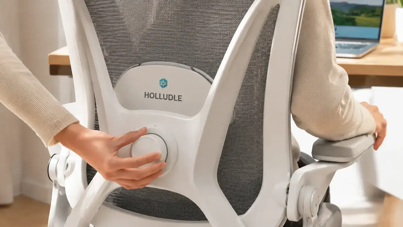 Close-up of the HOLLUDLE chair lumbar support dial being adjusted by a hand, showing the 3D mechanism depth and height controls